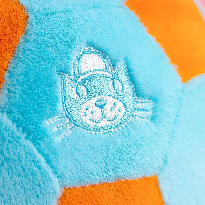 Close-up of a plush toy with an embroidered Jellycat logo  on a blue and orange background