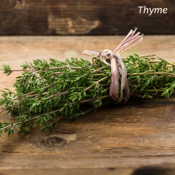 Sprigs of Thyme tied together and placed on a wooden kitchen table.