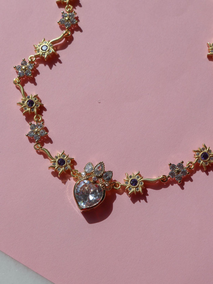 Rapunzel Royal Wedding Necklace with white flower motifs and a larger crystal pendant, displayed against a pink background.