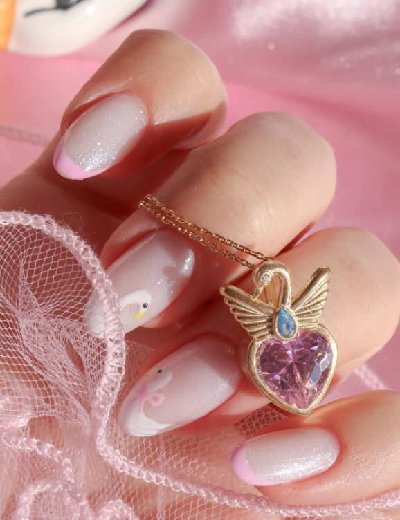 Swan Princess Necklace 925 Sterling Silver with a heart-shaped pendant featuring a pink gemstone on a pink background.