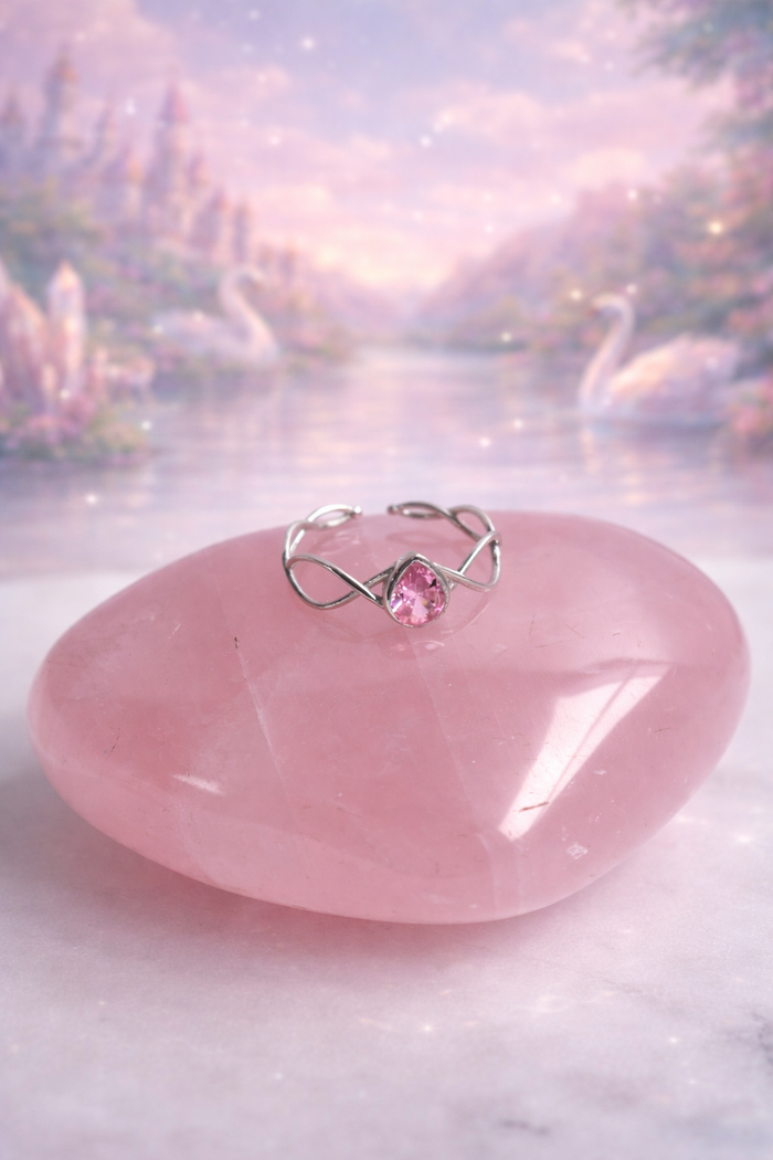 Swan Princess Odette Pink Stone Tiara Ring with a pink gemstone on a pink stone with a blurred nature background